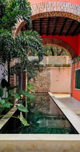 a pool of water in front of a building at Hotel Casa de la Acequia in Santa Marta
