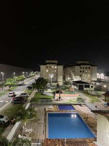 a swimming pool in the middle of a city at night at Apartamento em condomínio COP30 in Marituba