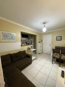 a living room with a couch and a kitchen at Apartamento em condomínio COP30 in Marituba
