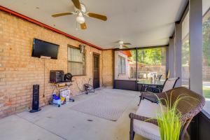 a living room with a ceiling fan and a brick wall at Pensacola Vacation Rental with Private Pool! in Pensacola