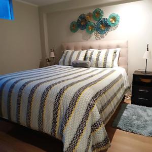 Un dormitorio con una cama con una manta azul y blanca. en Casa Fior, en Puno