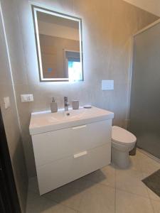 a bathroom with a sink and a toilet and a mirror at Pizzo Beach Club Luxury Apartment in Pizzo