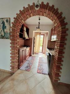 a brick archway in a kitchen with an open door at Angelica's beachside apartment in Porto Columbu - Perdʼe Sali
