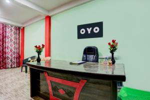 Una oficina con un escritorio con un cartel en la pared. en Hotel O SPARKLE, en Kānpur