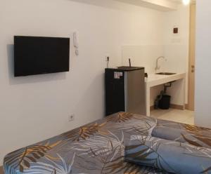 a bedroom with a bed and a flat screen tv at Budget-Friendly Staycation in Tokyo Riverside PIK2 in Gedong