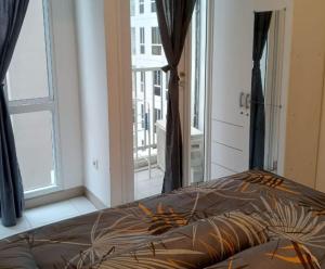 a bedroom with a bed and a large window at Budget-Friendly Staycation in Tokyo Riverside PIK2 in Gedong