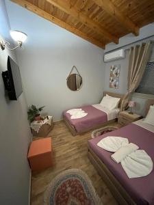 a room with two beds and a tv in it at Blue waves house 1 in Rhodes Town