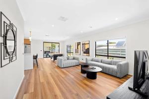 a living room with a couch and a tv at Stunning Beach Side Family Home in St Leonards in Saint Leonards