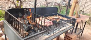 een grill met een hoop vlees erop bij Hotel Boutique Watungasta in El Puesto