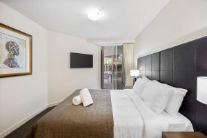 a bedroom with a large bed and a television at ZANZ205- Exclusive Outdoor Spa with Ocean Glimpses in Mooloolaba