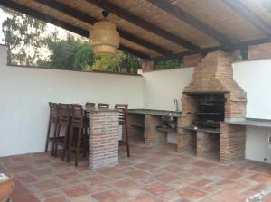 un patio con chimenea, mesa y sillas en Casa Lake Viñuela, en Viñuela