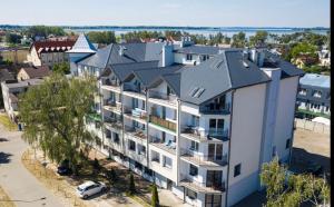 - une vue aérienne sur un grand immeuble blanc dans l'établissement Apartament YAGI z bezpłatnym parkingiem Dziwnówek nad morzem EPapartamenty, à Dziwnówek