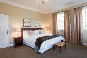 Un dormitorio con una cama grande y una lámpara de araña. en Capeblue Manor House, en Lakeside