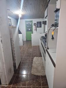 cocina con electrodomésticos blancos y suelo de baldosa. en Cantinho dos Gama, en São Gabriel