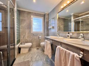 ein Badezimmer mit zwei Waschbecken und einer Toilette und einem Spiegel in der Unterkunft Lemon Playa in Málaga + 36 Fotos