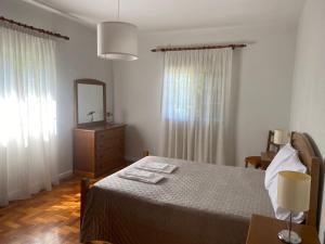 ein Schlafzimmer mit einem Bett mit Spiegel und einer Kommode in der Unterkunft Leiras da Cachada - Gerês in Valdosende + 14 Fotos