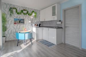 a kitchen with white cabinets and a blue table at Gold Coast Photography Inn in Estoril