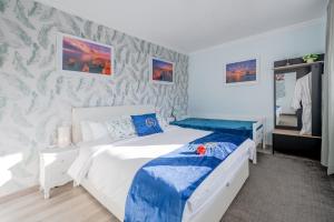 a bedroom with a white bed with blue sheets at Gold Coast Photography Inn in Estoril