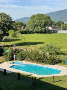a person standing next to a swimming pool in a field at Monoambiente 1 Village Golf in Yerba Buena