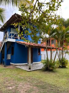a blue house with a palm tree in front of it at Kitnet Elles in Marau
