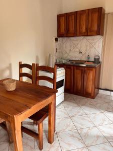 a kitchen with a table and a white stove top oven at Kitnet Elles in Marau