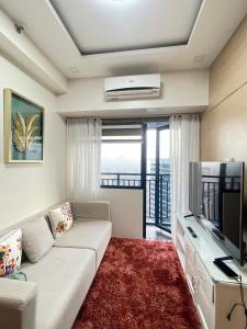 马尼拉Beauty Makati Penthouse 4 room Family Condo的配有沙发和平板电视的客厅