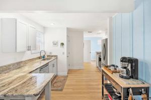 a kitchen with white cabinets and a counter top at Dog Friendly Cottage Just North of Historic St Aug in Saint Augustine +22 photos