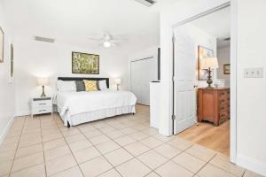 a white bedroom with a bed and a ceiling fan at Dog Friendly Cottage Just North of Historic St Aug in Saint Augustine