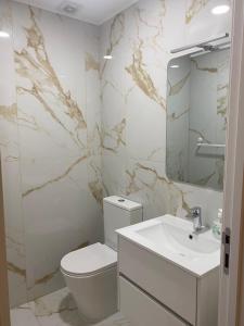 ein weißes Badezimmer mit Toilette und Waschbecken in der Unterkunft Leiras da Cachada - Gerês in Valdosende