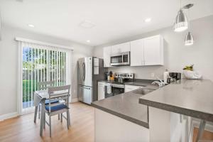 a kitchen with white appliances and a table and chairs at Secret Cottage 10 min to DT Dogs OK BBQ Parking in Saint Augustine