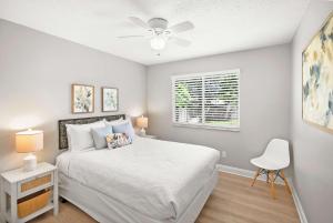 a bedroom with a bed and a ceiling fan at Secret Cottage 10 min to DT Dogs OK BBQ Parking in Saint Augustine