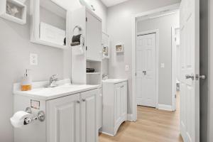 a white bathroom with a sink and white cabinets at Secret Cottage 10 min to DT Dogs OK BBQ Parking in Saint Augustine +26 photos
