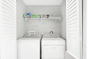 a bathroom with a washer and dryer in a room at Secret Cottage 10 min to DT Dogs OK BBQ Parking in Saint Augustine