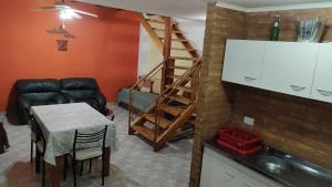 a living room with a table and a staircase at XayEm Apart in Villa Carlos Paz