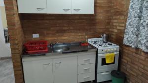 a small kitchen with a sink and a stove at XayEm Apart in Villa Carlos Paz