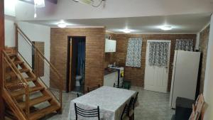 a kitchen with a table and a refrigerator and stairs at XayEm Apart in Villa Carlos Paz +2 photos