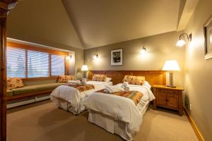 a bedroom with two beds and a couch at Vagabond Lodge at Kicking Horse in Golden