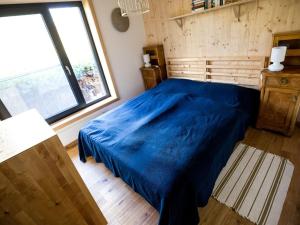 Un dormitorio con una cama azul y una ventana. en "NisseHus" Comfortable holiday residence, en Felli
