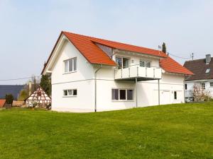 a white house with an orange roof on a green field at Beech Modern Retreat in Hödingen +17 photos