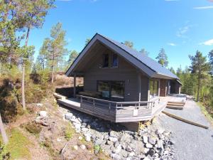 a small house on a hill with trees and rocks at "NisseHus" Comfortable holiday residence in Felle +17 photos