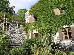 an ivy covered building with windows and doors at Holiday home Mirabel Sous les roches in Mirabel
