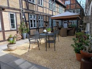 Un patio con una mesa y sillas frente a un edificio. en De Böhn Comfortable holiday residence, en Travemünde