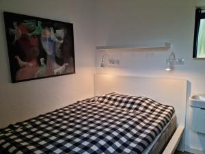 a bed in a room with a checkered at The Blue House Modern retreat in Wangerooge