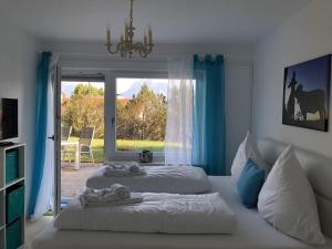 a bedroom with two beds and a large window at Villa Alpenblick Comfortable holiday residence in Füssen