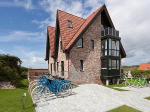 a house with a blue bike parked in front of it at Dünenhuus Ost Modern retreat in Juist