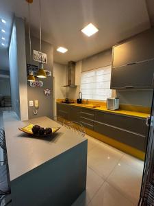 イタペマにあるApartamento Meia Praiaのキッチン(テーブルにフルーツプレート付) +5枚の写真