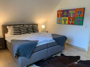 una camera da letto con un letto e un dipinto sul muro di Villa Seebrise Modern retreat a Göhren-Lebbin