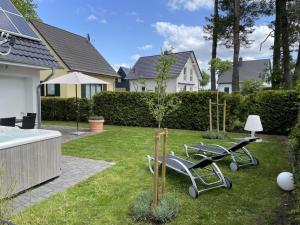 un giardino con due sedie da giardino e un albero di Villa Seebrise Modern retreat a Göhren-Lebbin