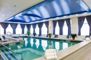 a large swimming pool with chairs in a building at Salem Waterfront Hotel & Suites in Salem