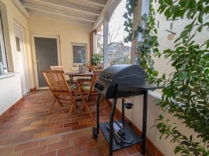 a grill on a patio with a table and chairs at "Schmiedegässchen" Comfortable holiday residence in Kamp-Bornhofen